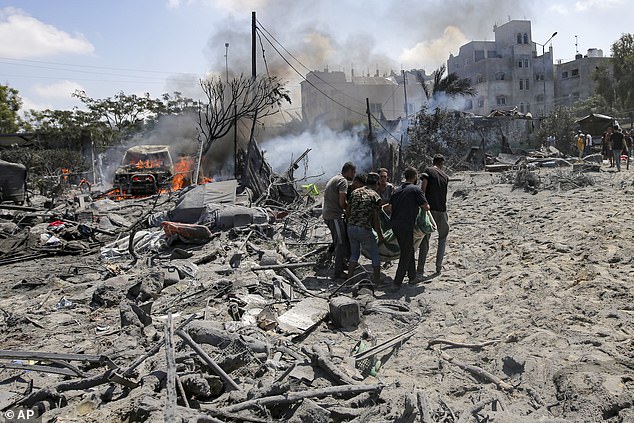 Palestinians evacuate a body from a site hit by Israeli shelling in Khan Younis, southern Gaza Strip, July 13.