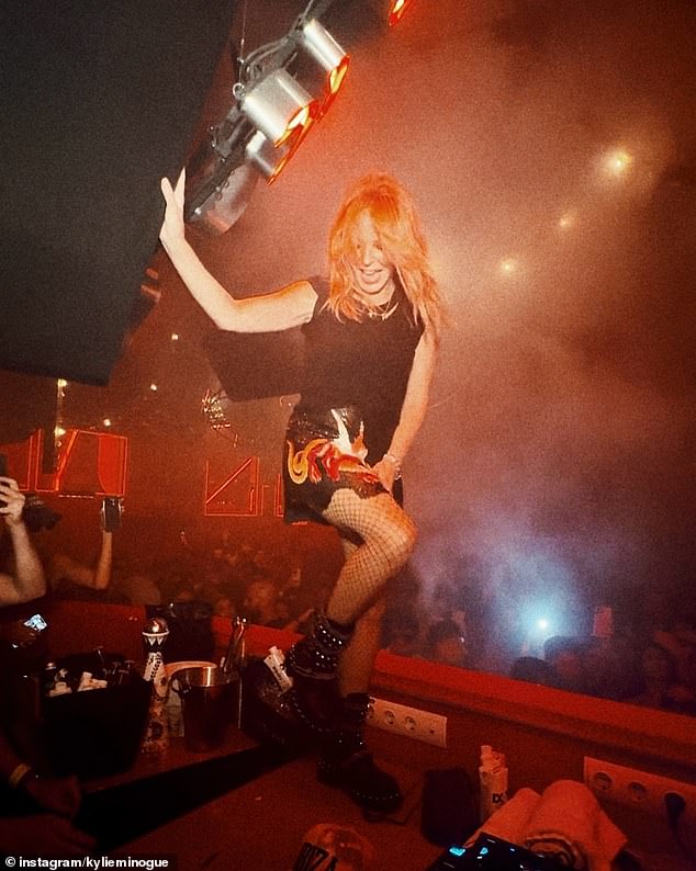 Wearing a black miniskirt and fishnet stockings, the Padam Padam singer raised her hands in the air as she danced on tables.