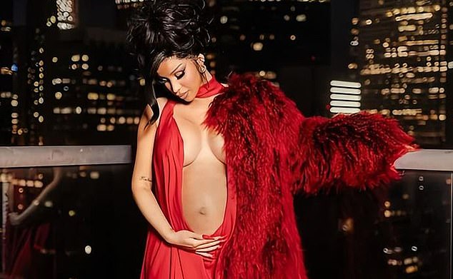 The rapper showed off her baby bump in a plunging red dress as she posed on a balcony at night.