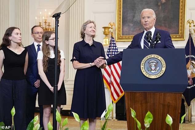 President Joe Biden, right, shakes hands with Elizabeth Whelan, center, as he delivers remarks on a prisoner swap with Russia. He was surrounded by family members of the prisoners released in the exchange as he announced the deal.