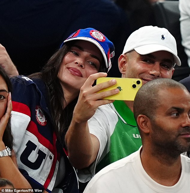 Jenner smiled for a selfie with a friend wearing a green and white T-shirt.