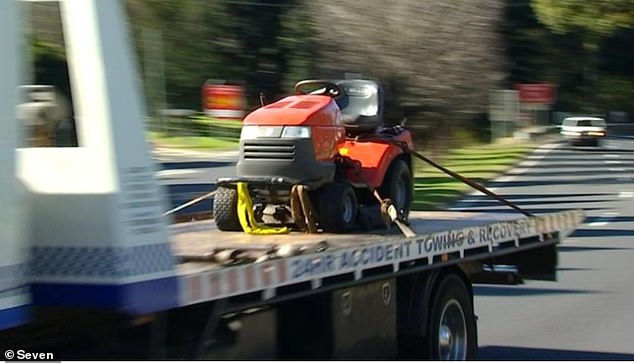 A lawnmower is seen being towed from Crawford's property on Tuesday.