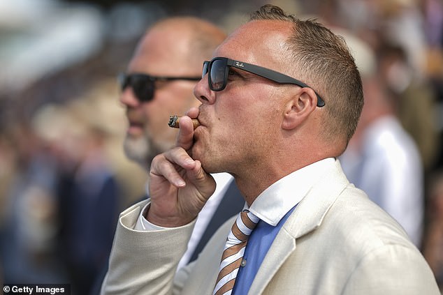 A smartly dressed man was photographed smoking a cigar on the penultimate day of the event.