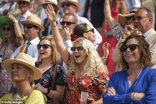 Attendees were photographed cheering as they held their glasses while watching the races.