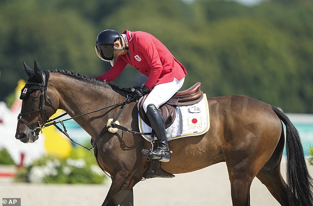 Japanese Yoshiaki Oiwa strokes his horse Mgh Grafton Street after competing in the show jumping competition