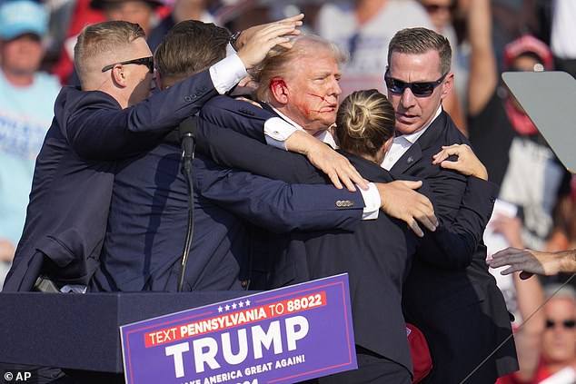 Former President Donald Trump is surrounded by his Secret Service team moments after a bullet grazed his ear at his July 13 rally in Butler, Pennsylvania.