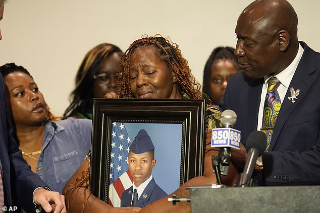 Civil rights attorney Ben Crump stands next to a tearful Chantemekki as she holds a photo of her beloved son.