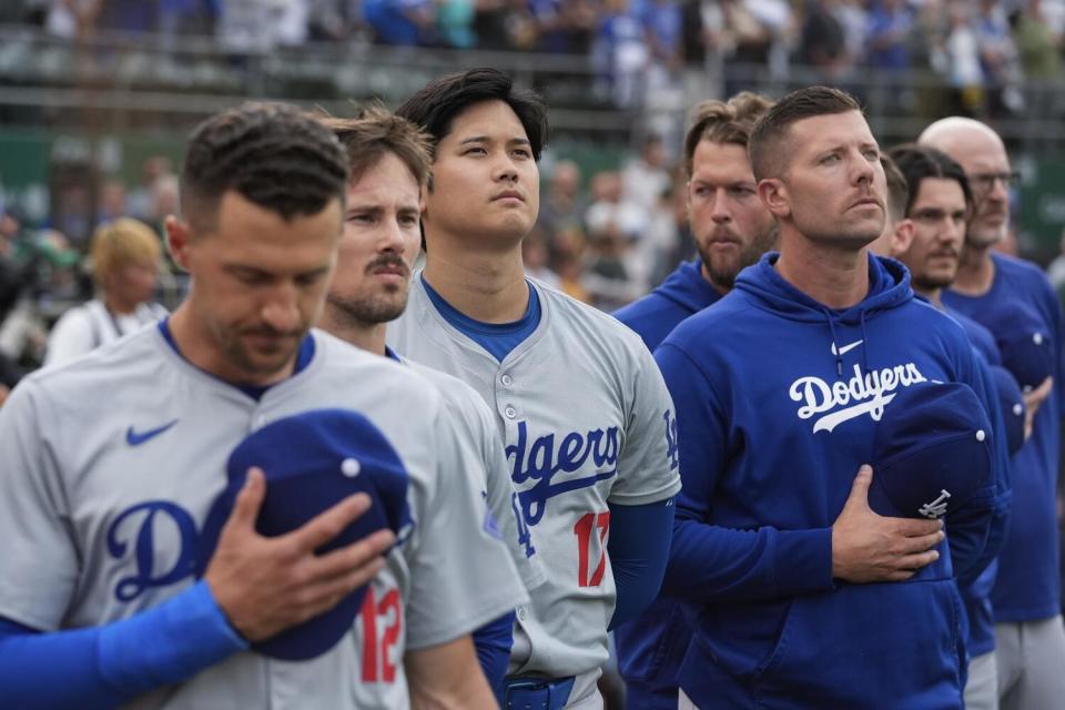 Dodgers' Shohei Ohtani and his teammates listen to the national anthem before playing the Athletics on Friday in Oakland.