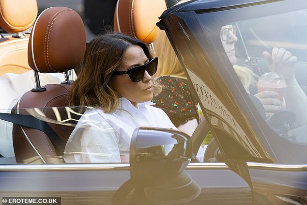 Rachel returned to her convertible and was seen driving with a friend in the passenger seat.