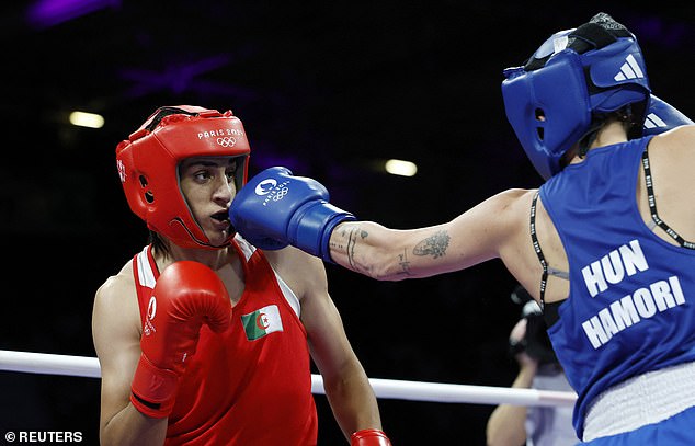 When Khelif entered the ring, she was greeted with thunderous applause and did a Ronaldo-style celebration, toning her knees and then doing weightlifting exercises with her arms raised high (pictured: the bozers during the fight)