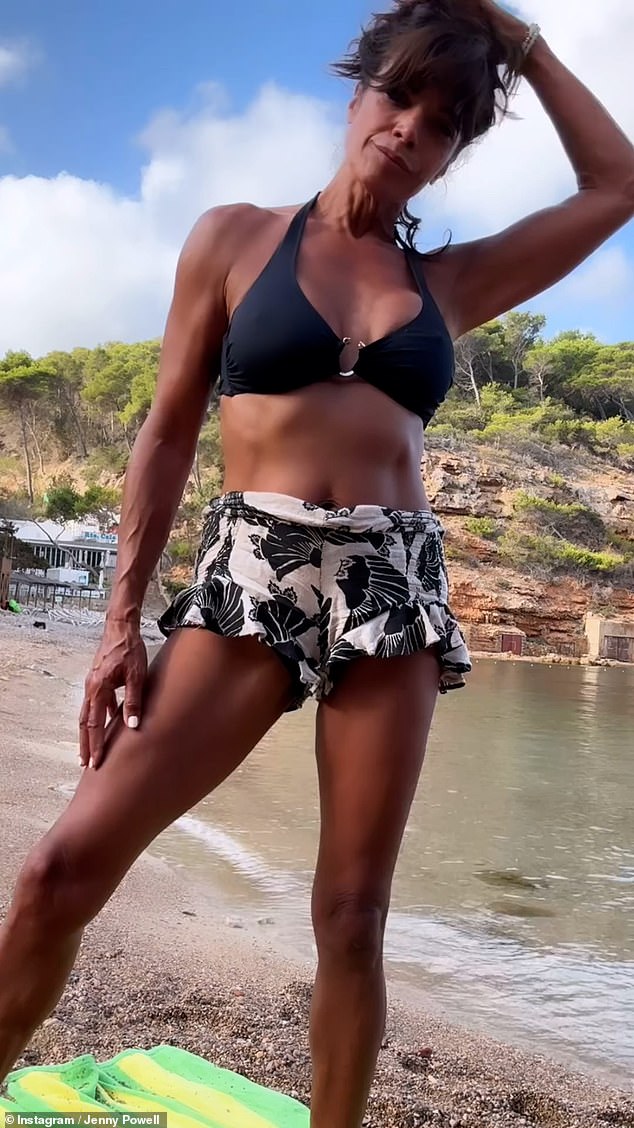 The TV presenter looked incredible as she showed off her toned abs in a black halterneck bikini top.