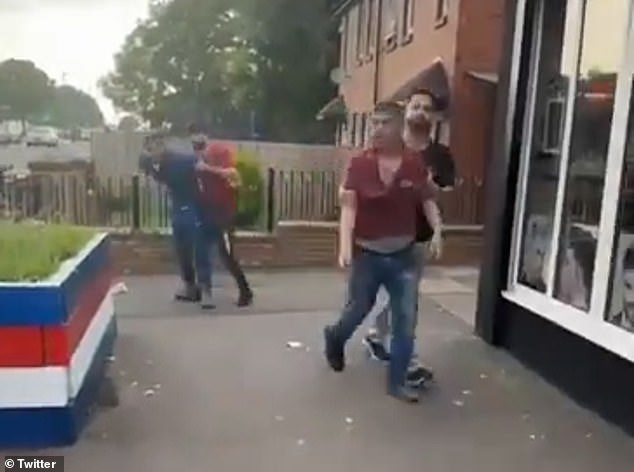 In the 25-second clip, a group of youths can be seen gathered around a man and throwing punches at him. A man wearing a red T-shirt is pulled away from the group by a second man wearing light-coloured trousers and a dark T-shirt.