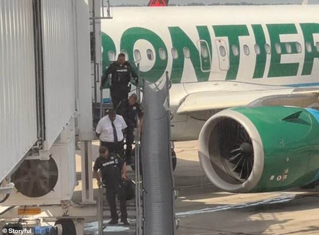 Frontier pilot Seymour Walker, 45, is pictured being arrested at George Bush Intercontinental Airport on Saturday on domestic abuse charges.