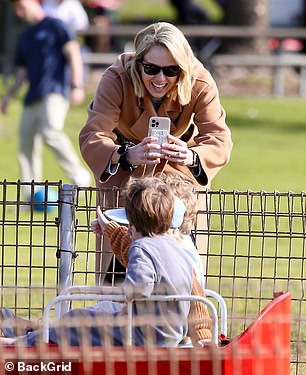 She held her phone while her children posed for the camera.