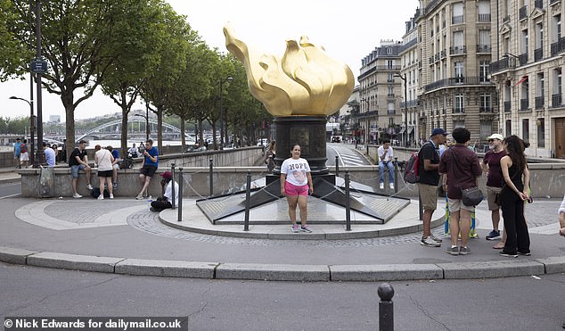 A woman poses next to the Flame of Liberty, which has become the unofficial memorial to Diana.