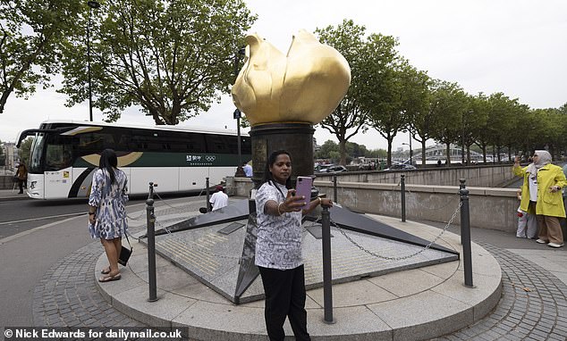 A woman takes a selfie next to the Flame of Liberty. Although it is not officially designated as a memorial to Diana, its proximity to the scene of the tragedy has made it a natural place for mourners to pay their respects.