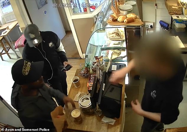 Pictured: Said-Baker and Said-Ahmed distract an employee at the Revival Cafe in Bristol as they steal thousands of pounds