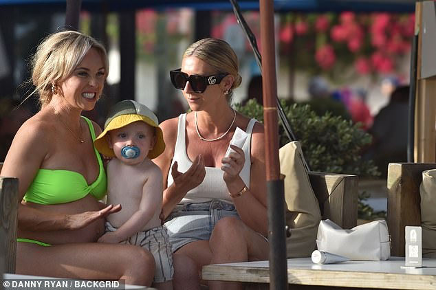 And later, Jorgie enjoyed a cuddle with her 21-month-old son Forest as she chatted with a friend.