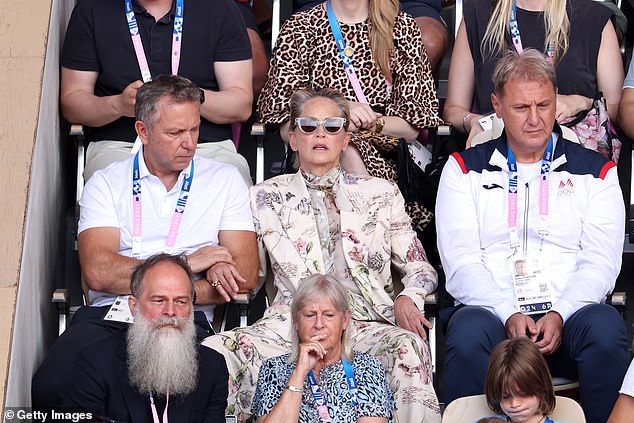 Sharon wore her long hair slicked back and put on a pair of sunglasses.