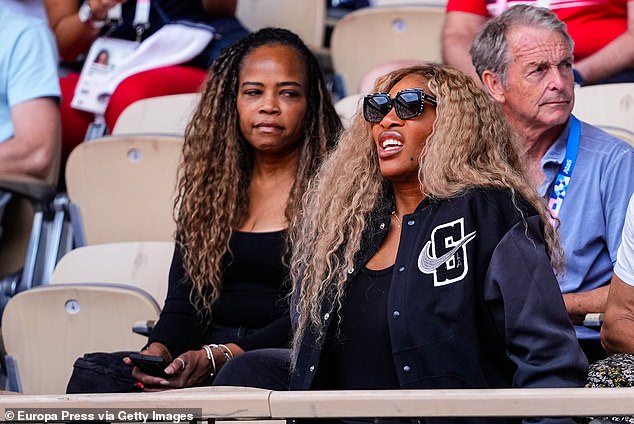 Her blonde curls were loose and contrasted with her black college jacket, tank top, pants, and sunglasses.