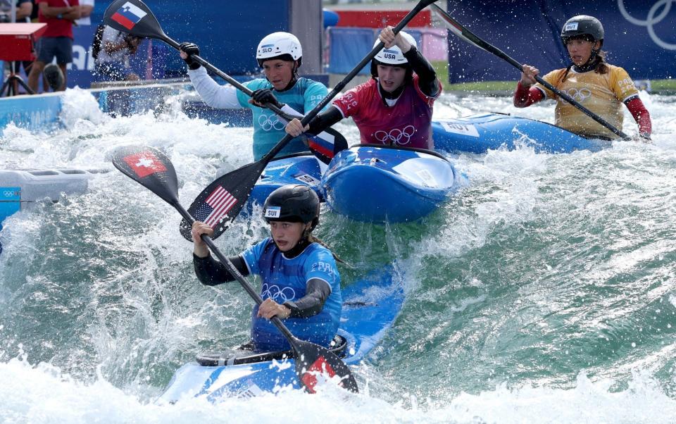 Kayak cross competitors descend a descent