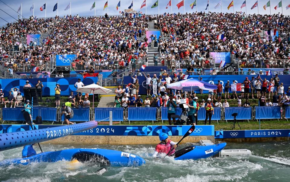 Taiwanese Wu Shao-hsuan performs an Eskimo turn as he competes against Frenchman Titouan Castryck (right) in the canoe slalom competition of the men's kayak cross qualifiers at the Stade Nautique de Vaires-sur-Marne