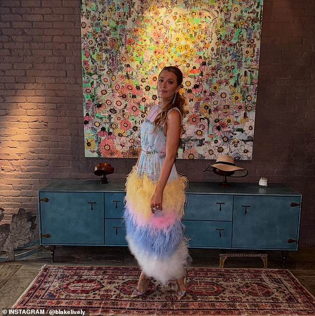 She posed animatedly in front of a large square portrait adorned with flowers and in front of a steel-blue dressing table with a hat and a wooden ornament on top.