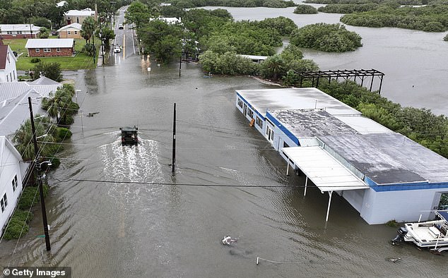 In an aerial view, a Florida National Guard vehicle moves down a street flooded by rain and storm surge caused by Hurricane Debby on August 5, 2024, in Cedar Key, Florida.