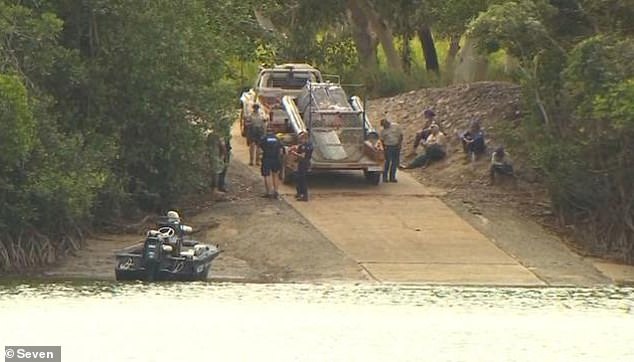 The 40-year-old man was attacked by a crocodile in front of his wife and children while fishing near the Annan River Bridge, south of Cooktown (pictured, a baited crocodile trap is placed in the water)