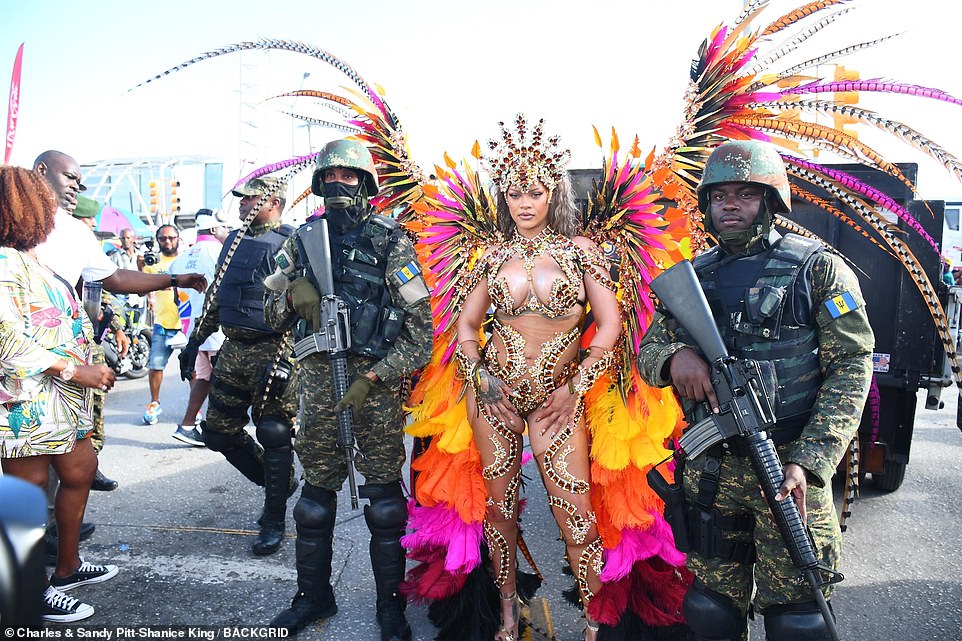 In a surprising move, Rihanna was flanked by armed soldiers holding large assault rifles as she walked out to join the crowd.