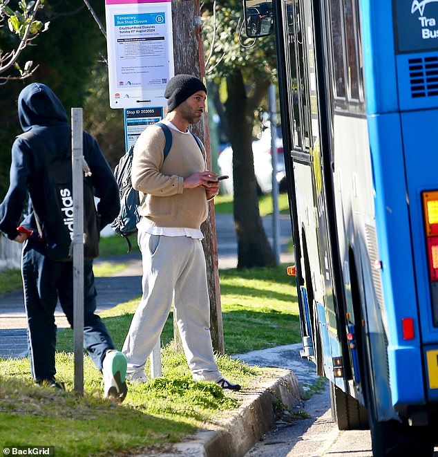 Alex was carrying a backpack that looked very full and was checking his phone before the bus arrived.