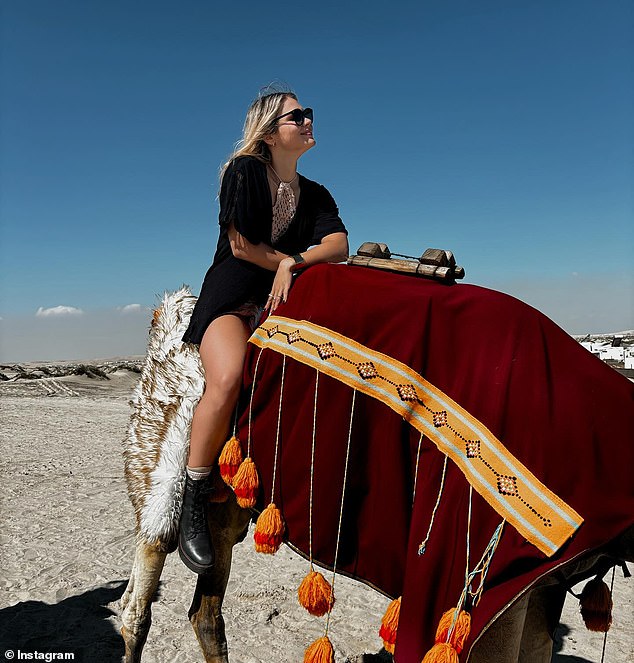 The glamorous swimmer rode a camel in the desert surrounding Doha while wearing a short, flowing black dress.