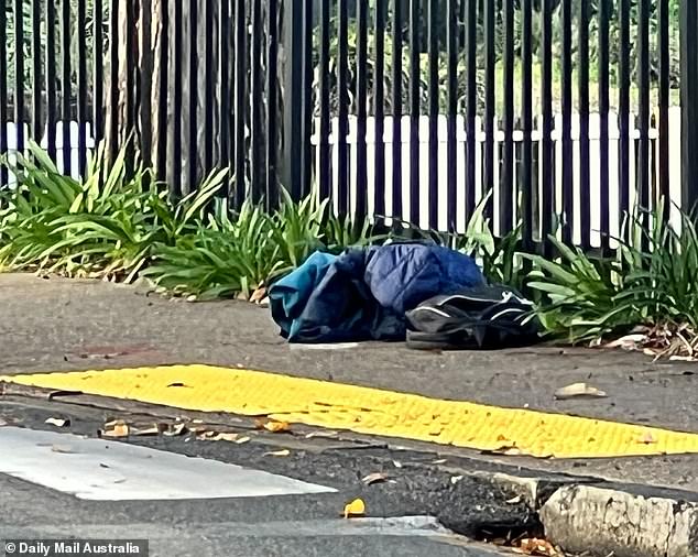 Photographs from the scene show a padded jacket and a backpack next to what appears to be a blood stain on the concrete at the university entrance (pictured).