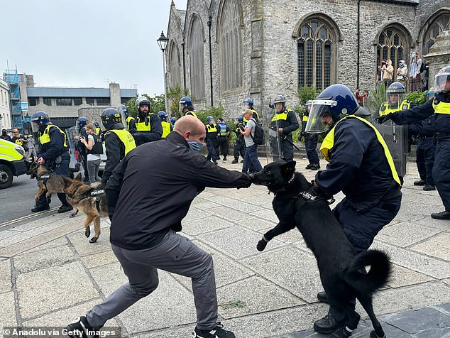 Police officers with dogs intervene after far-right protesters pushed past anti-racism activists and clashed with police in Guildhall Square in Plymouth