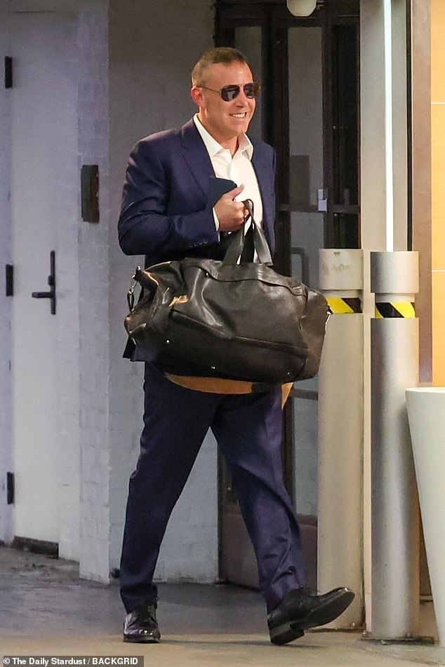 The 51-year-old actor was again seen without a wedding ring as he cheerfully arrived at his office, dressed in a suit and holding an iced coffee.