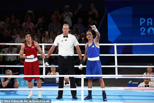 Match referee Shawn Reese raises Imane Khelif's arm to announce the winner of the women's 66kg semi-final round match.