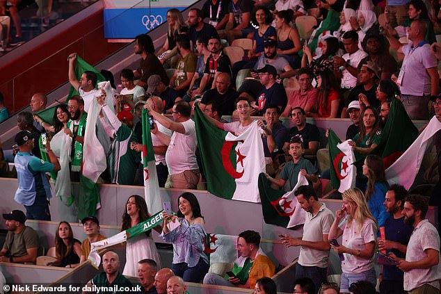 Algerian fans stand up as Imane Khelif enters the stadium.