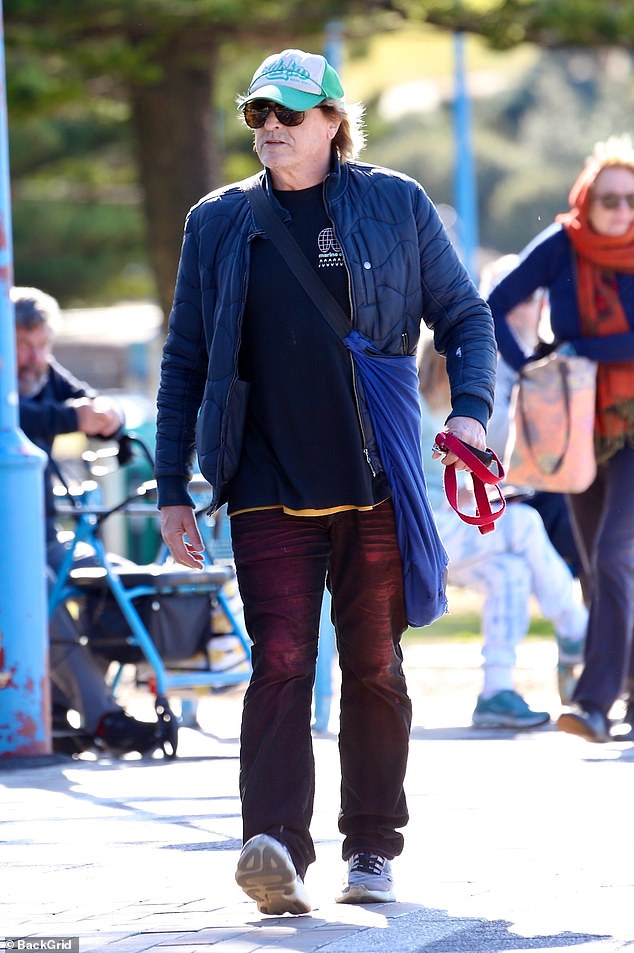 Peter wore a navy puffer jacket over a black graphic tee, paired with burgundy jeans.