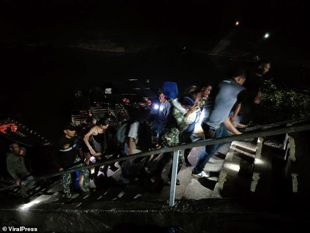 Rescuers carry injured members of the hiking group back to the cave after their rescue.