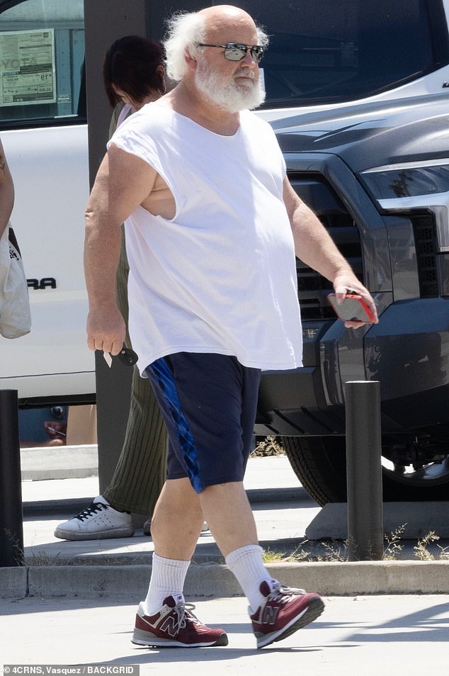 The single father was seen wearing a white tank top, navy blue shorts, a pair of sunglasses and a summer hat as he walked briskly with a cheerful-looking Paulson.