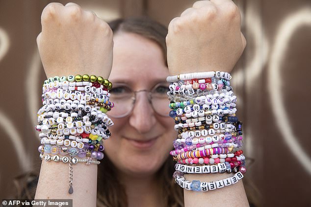 A fan of American singer Taylor Swift, a Swiftie, proudly presents her numerous friendship bracelets