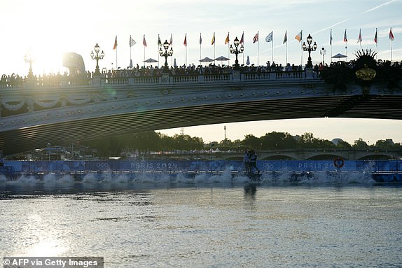 Athletes jump into the River Seine for the start of the men's 10km marathon swimming final at the Paris 2024 Olympic Games on the Pont Alexandre III in Paris on August 9, 2024. (Photo by Dimitar DILKOFF / AFP) (Photo by DIMITAR DILKOFF/AFP via Getty Images)