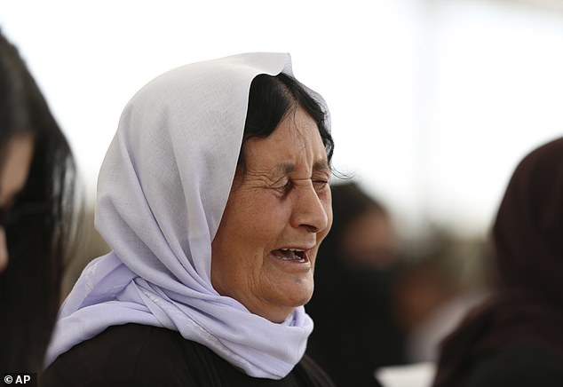 An Iraqi Yazidi woman mourns the loss of her family members during a genocide commemoration in Sinjar