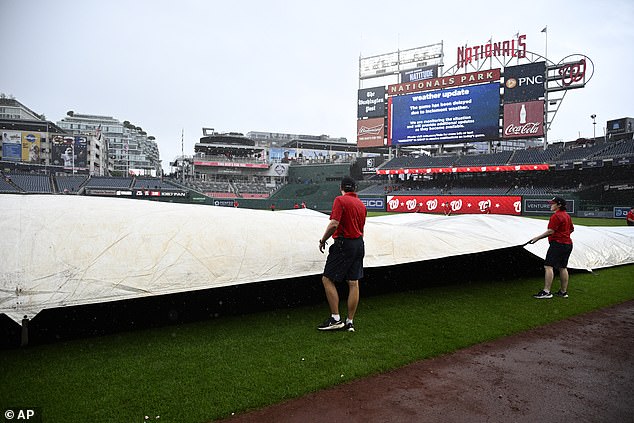 The Washington Nationals' grounds crew rolls out a tarp to cover the field during a weather delay in the eighth inning of a baseball game between the Nationals and the San Francisco Giants on Thursday.