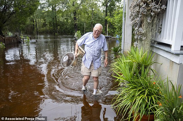 Charles Grainger cleans up around his home Wednesday in the French Quarter Creek Historic District as flood waters from Tropical Storm Debby recede