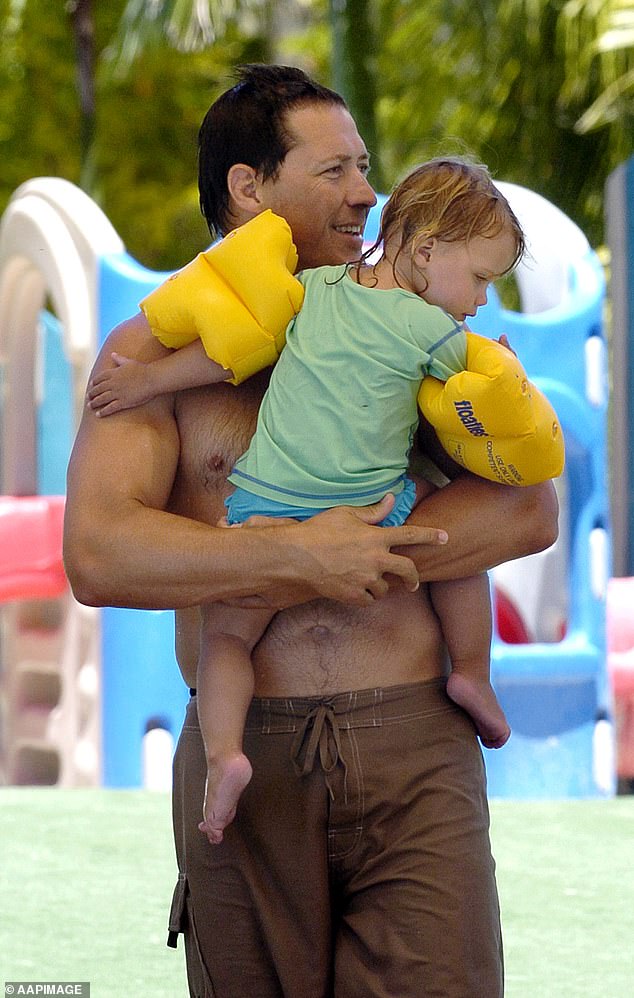 Wallaby Phil Kearns is pictured holding his 20-month-old daughter Andie in 2005, the year a tragic accident nearly claimed his life.