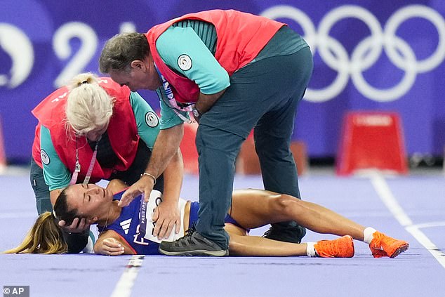 Alessia Zarbo of France is treated on the track during the women's 10,000m race