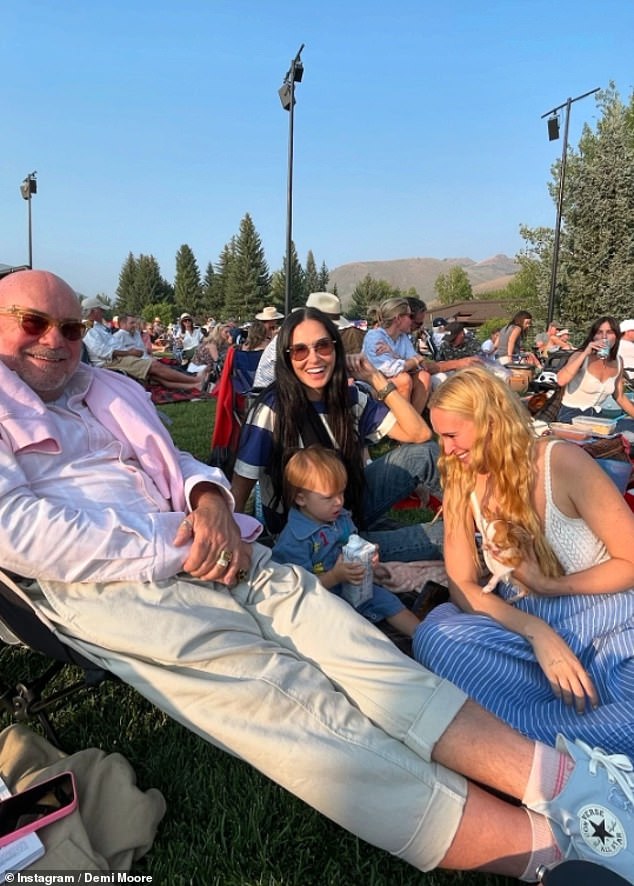 Bruce Willis was photographed relaxing in a garden chair with his ex-wife and daughters around him.