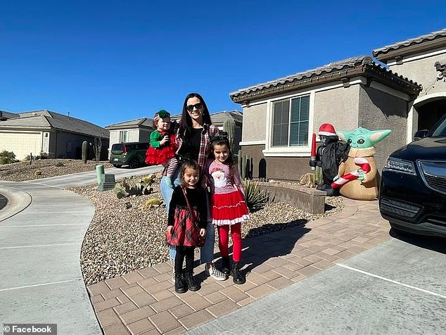 Parker with his mother Erika and two sisters outside their Tucson home on Halloween, just yards from where he died.