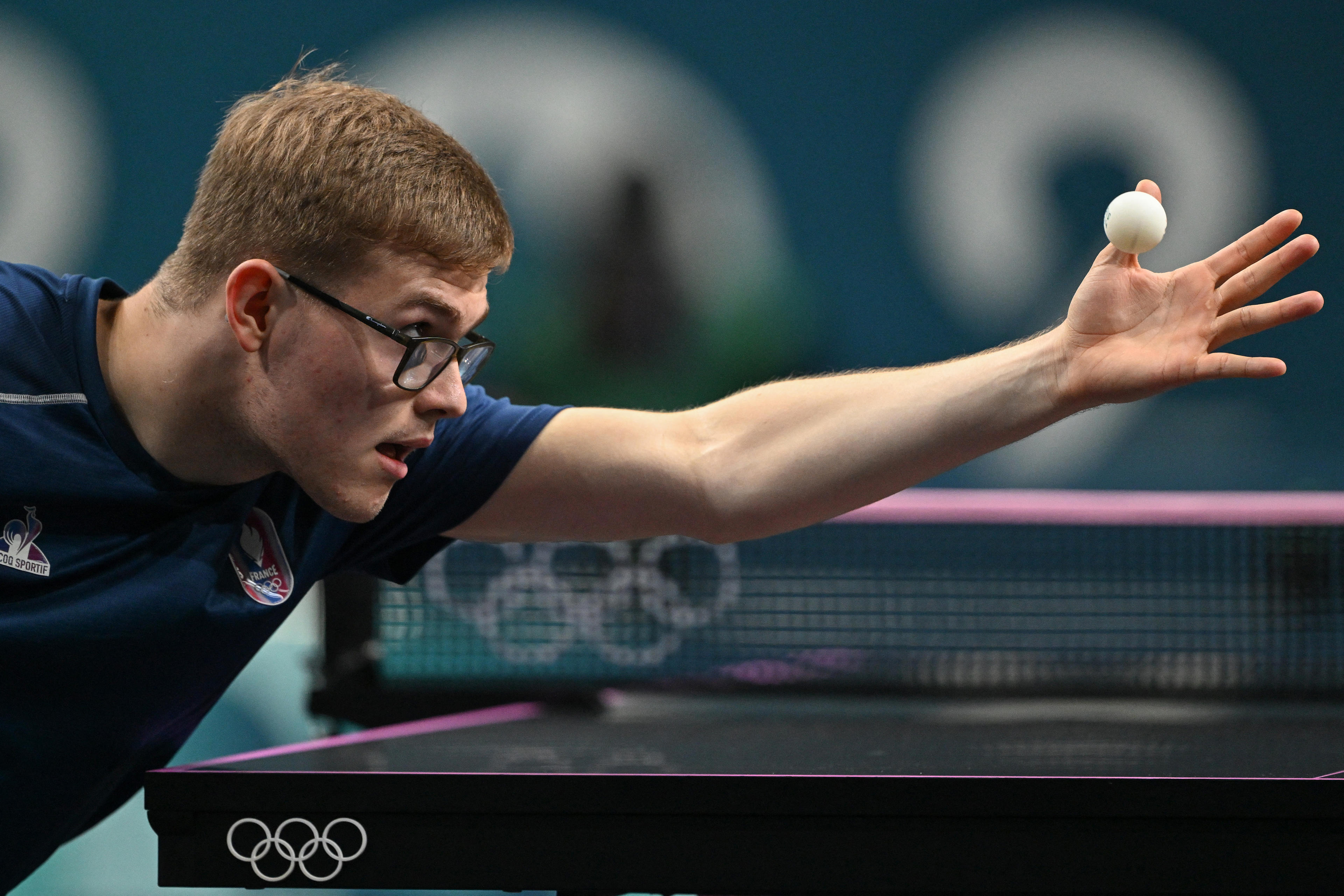 France's Alexis Lebrun looks at the ball as he serves during their men's singles table tennis match in the team bronze medal match between France and Japan at the Paris 2024 Olympic Games at the South Paris Arena in Paris on August 9, 2024. (Jung Yeon-je/AFP/Getty Images)